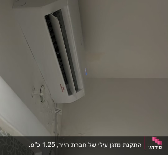 התקנת מזגן עילי מפוצל בצבע לבן על הקיר